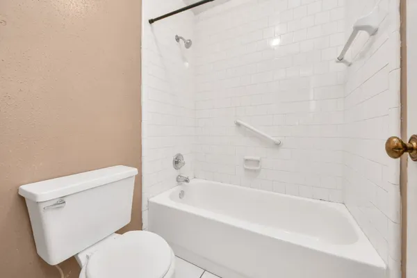 a white toilet sitting next to a bath tub
