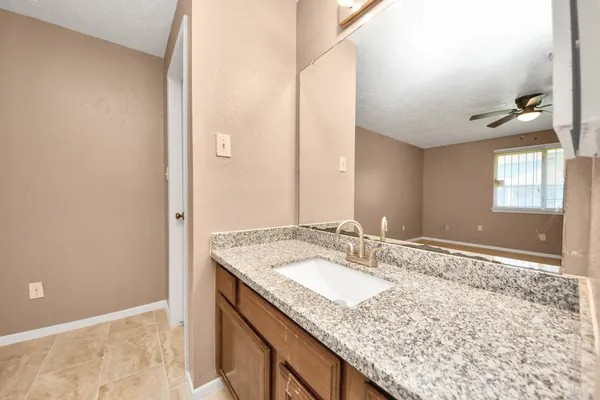 a bathroom with a granite countertop sink and a mirror
