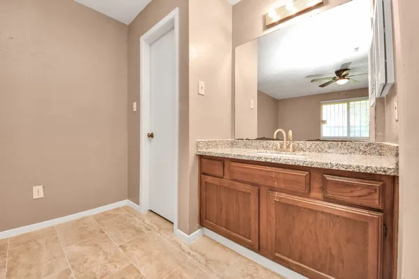 a bathroom with a granite countertop sink and a mirror
