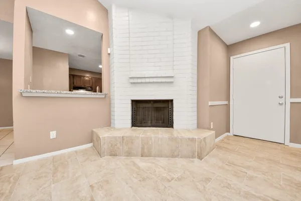 a view of a livingroom with an empty space and a fireplace