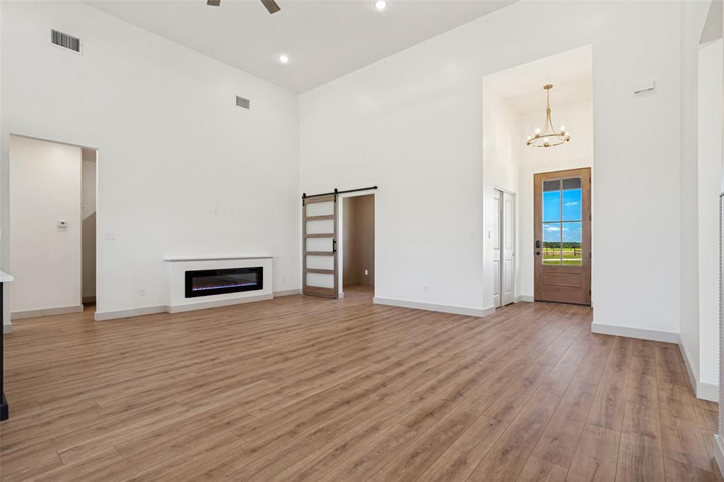 1150 Doss Road Millsap, TX 76066 - Photo 17 of 32 Spacious living area featuring high ceilings, wood-finish flooring, and a built-in electric fireplace