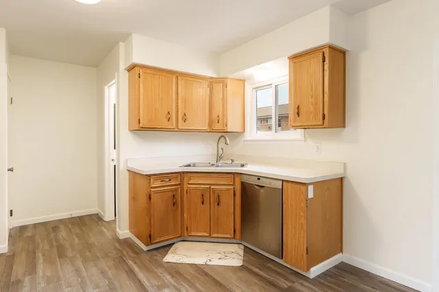 a kitchen with stainless steel appliances granite countertop a sink and wooden cabinets