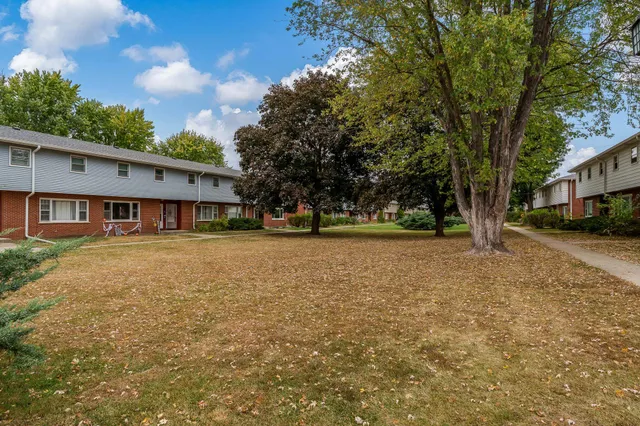 a front view of a house with a yard and trees