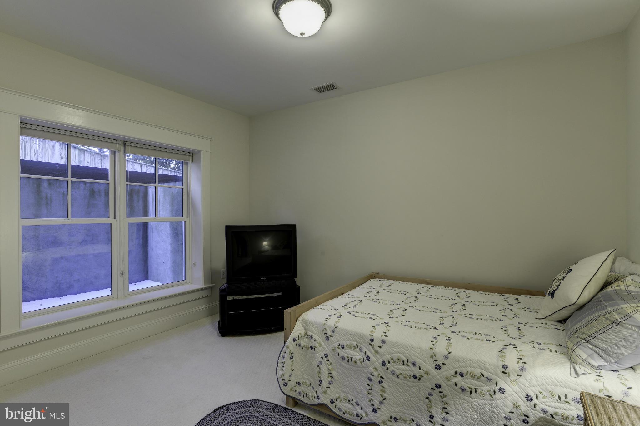 8007 Custer Road Bethesda, MD 20814 - Photo 20 of 25 a bedroom with a bed and a television