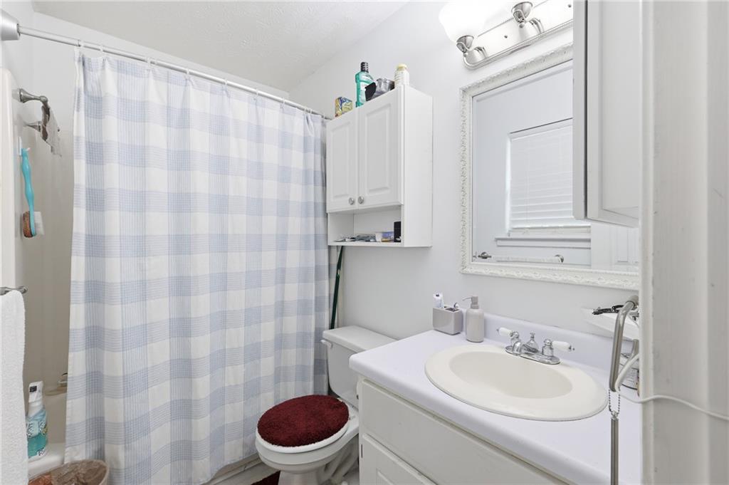 211 Brooks Lane Winder, GA 30680 - Photo 18 of 27 a bathroom with a sink a toilet and shower curtain