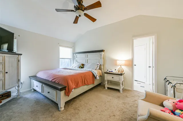 a spacious bedroom with a bed and a flat screen tv