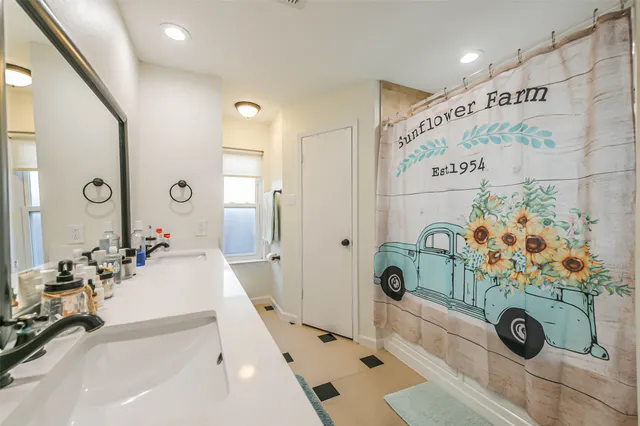 a spacious bathroom with a double vanity sink mirror and double