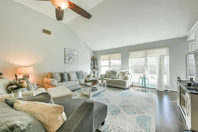 a living room with furniture a flat screen tv and a fireplace