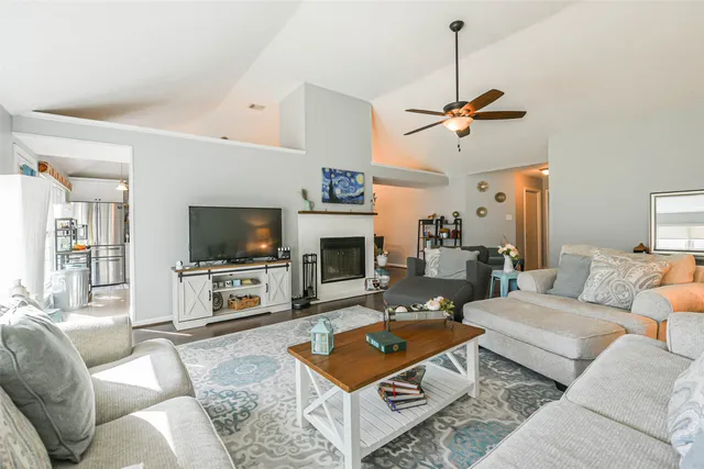 a living room with furniture a fireplace and a large window