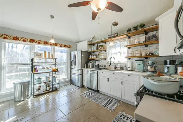a kitchen with stainless steel appliances granite countertop a sink and a refrigerator