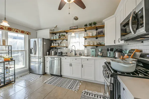 a kitchen with granite countertop a refrigerator stove top oven and sink