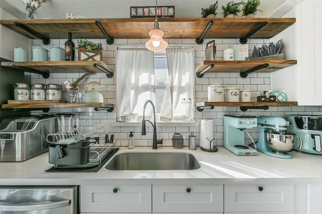 a kitchen with stainless steel appliances a sink and cabinets