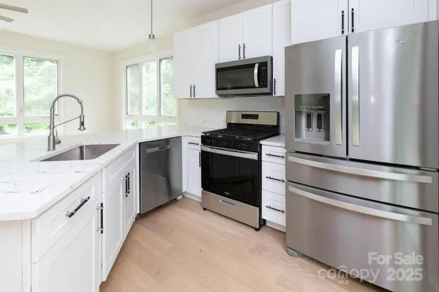 a kitchen with stainless steel appliances a refrigerator stove microwave and sink
