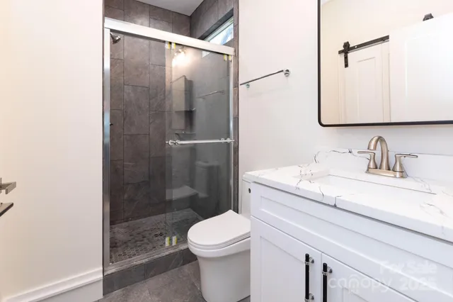 a bathroom with a granite countertop sink toilet and shower