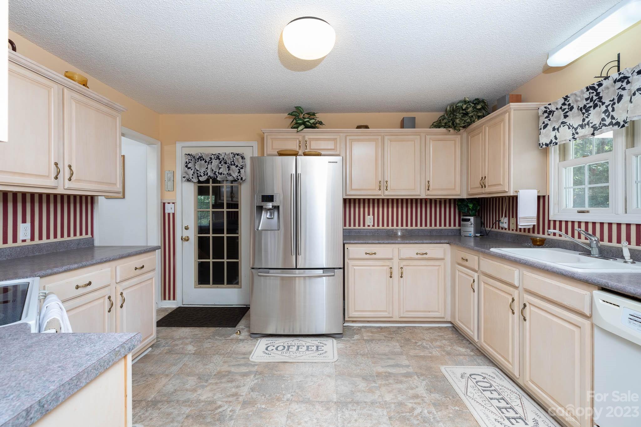 1598 Glenway Road Clover, SC 29710 - Photo 26 of 36 a kitchen with granite countertop a refrigerator a sink and white cabinets