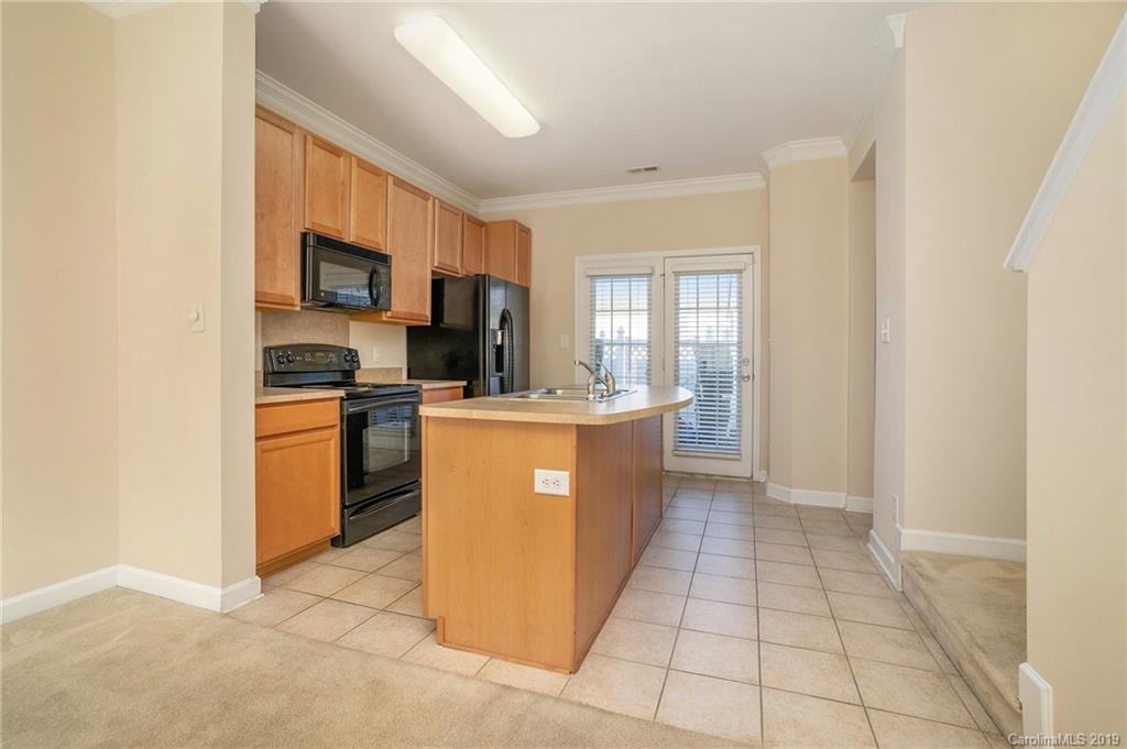5132 Prosperity Church Road Charlotte, NC 28269 - Photo 12 of 32 a kitchen with stainless steel appliances a sink a stove a microwave a counter top space and cabinets