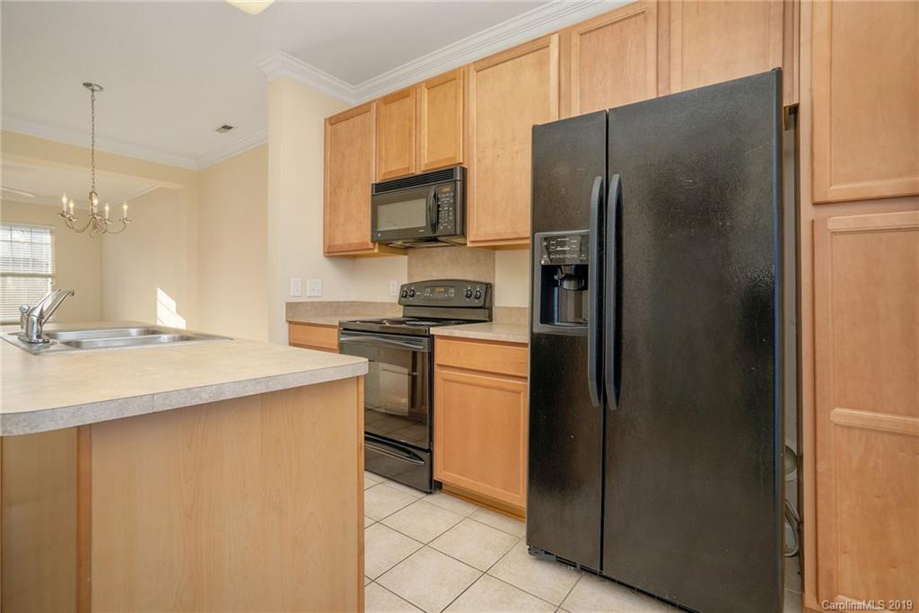 5132 Prosperity Church Road Charlotte, NC 28269 - Photo 14 of 32 a kitchen with a refrigerator and a sink