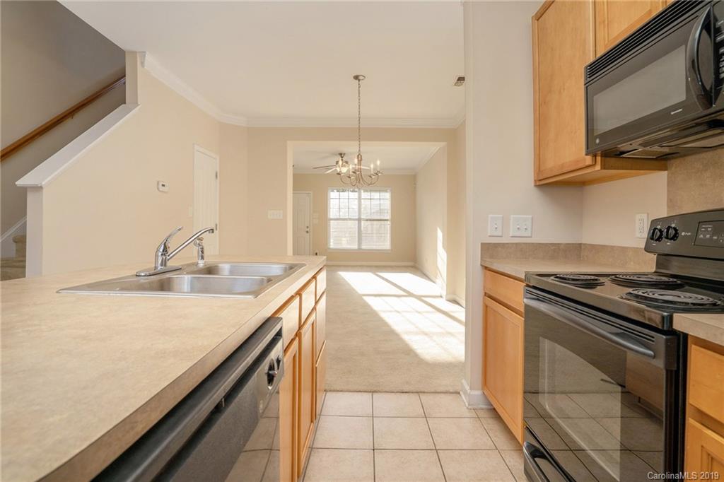 5132 Prosperity Church Road Charlotte, NC 28269 - Photo 15 of 32 a kitchen with stainless steel appliances granite countertop a sink a stove and a microwave