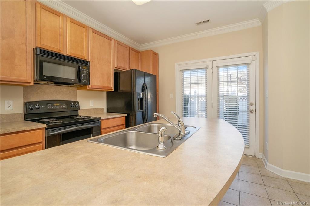 5132 Prosperity Church Road Charlotte, NC 28269 - Photo 16 of 32 a kitchen with stainless steel appliances a stove sink microwave and refrigerator