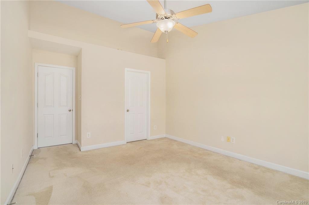 5132 Prosperity Church Road Charlotte, NC 28269 - Photo 25 of 32 an empty room with a ceiling fan and a window