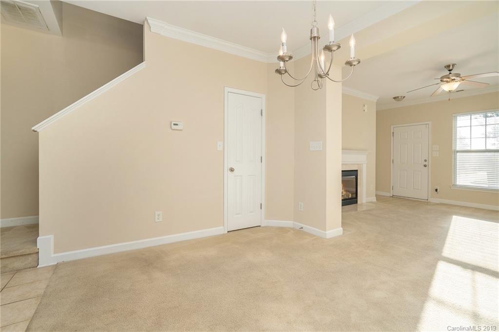 5132 Prosperity Church Road Charlotte, NC 28269 - Photo 6 of 32 an empty room with a chandelier fan and windows