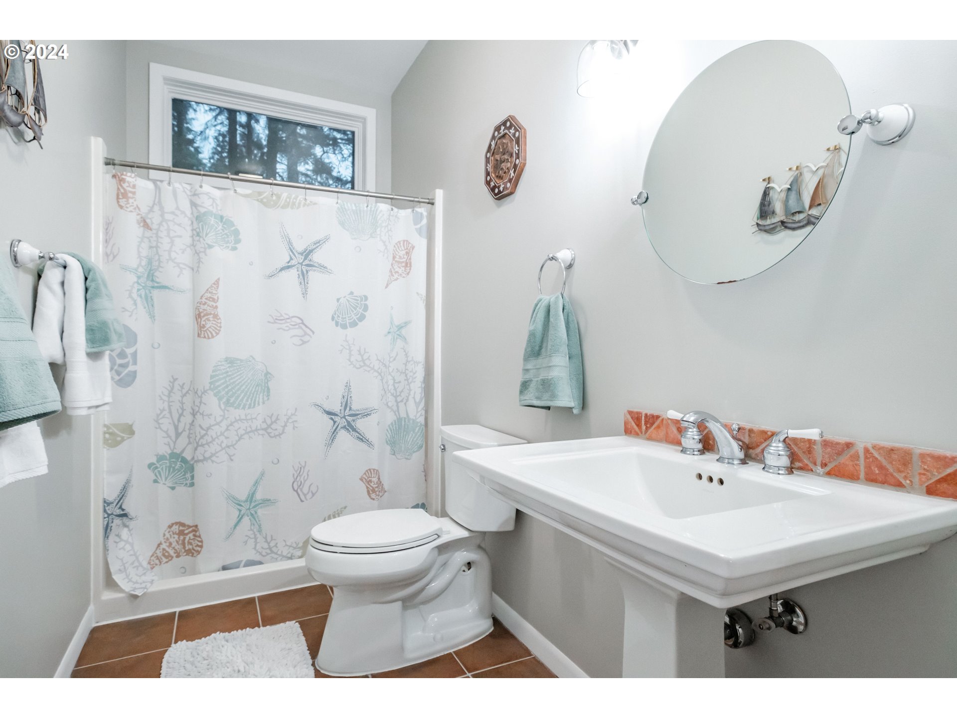 9350 Whiskey Creek Road Tillamook, OR 97141 - Photo 25 of 32 a bathroom with a sink a toilet and a mirror