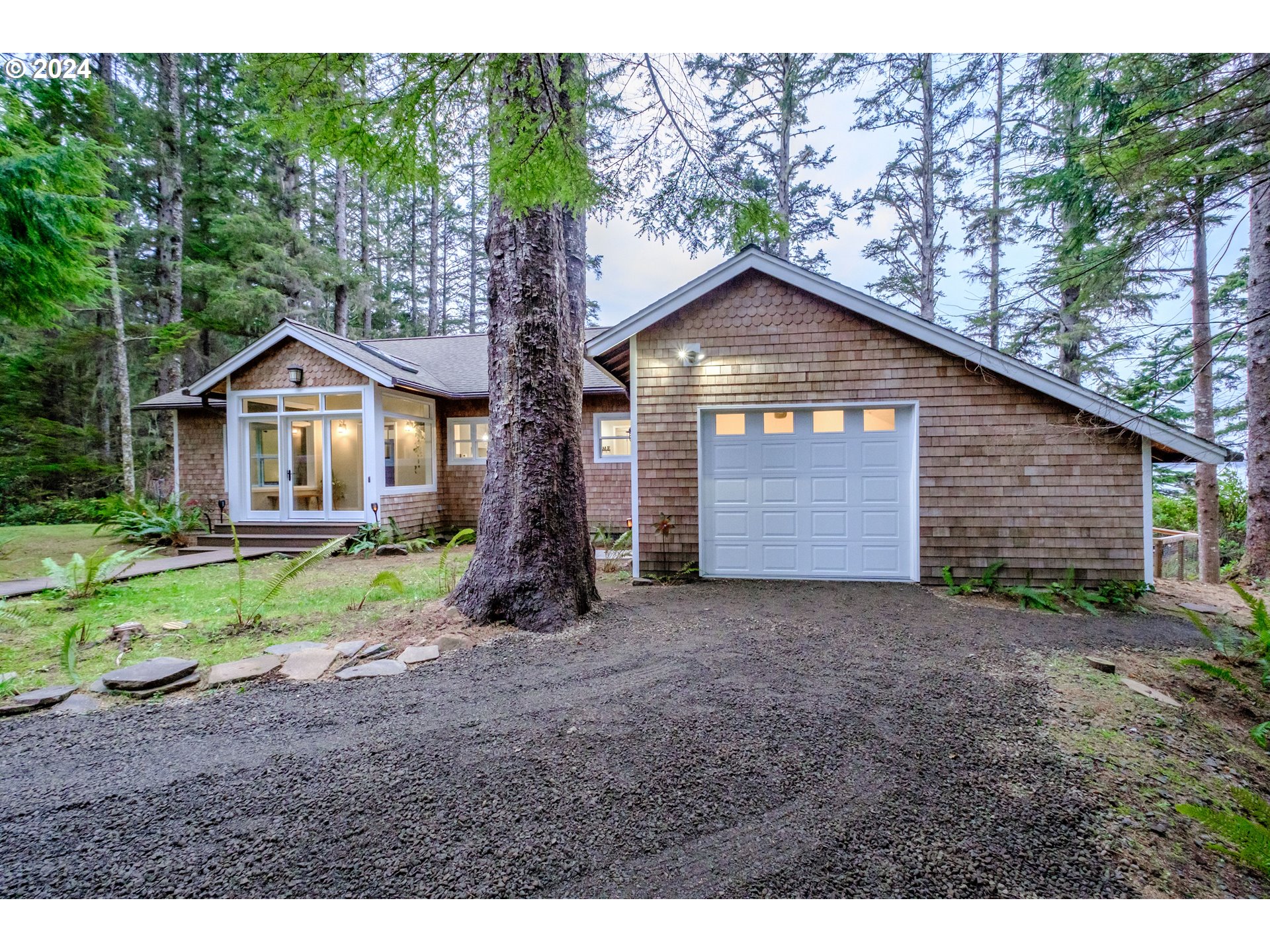 9350 Whiskey Creek Road Tillamook, OR 97141 - Photo 5 of 32 a front view of a house with a yard and garage