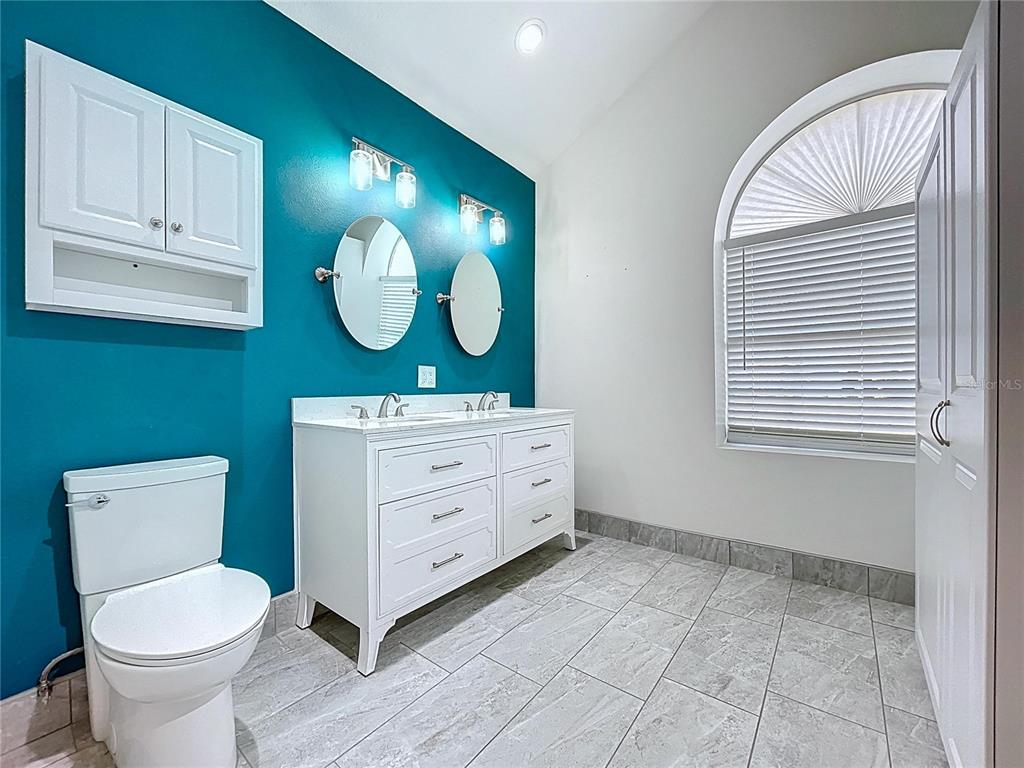 18812 Bascomb Lane Hudson, FL 34667 - Photo 39 of 57 a bathroom with a toilet sink and mirror