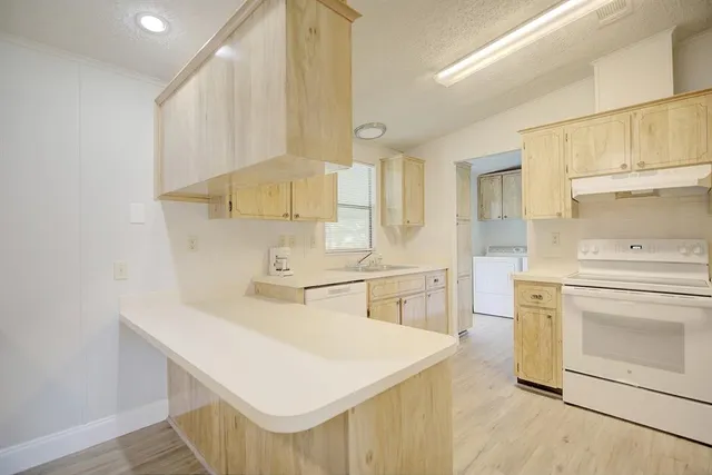 a kitchen with a sink a stove and cabinets