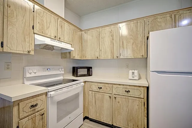 a kitchen with stainless steel appliances white cabinets and a refrigerator