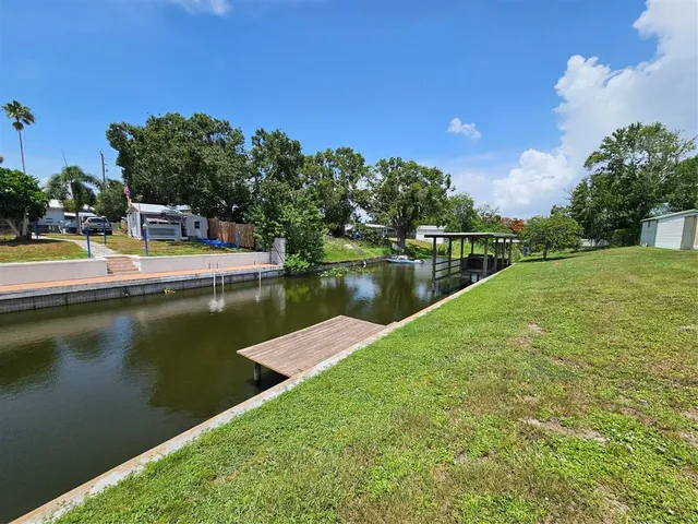 a view of a big house with a big yard plants and large trees