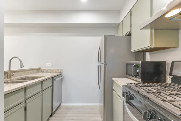 a kitchen with stainless steel appliances granite countertop a refrigerator sink and stove