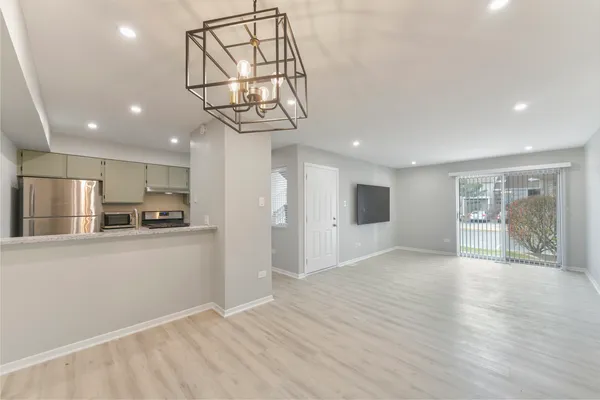 a view of a kitchen with a sink and dishwasher a refrigerator with wooden floor