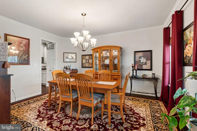 a view of a dining room with furniture a chandelier and wooden floor