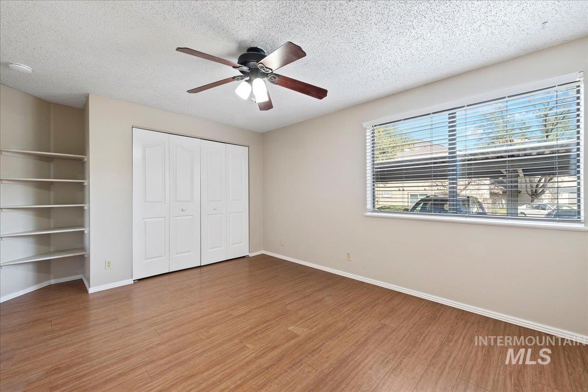 3611 South Gekeler Lane, Unit 124 Boise, ID 83706 - Photo 11 of 27 Unfurnished bedroom with a textured ceiling, ceiling fan, light wood-type flooring, and a closet