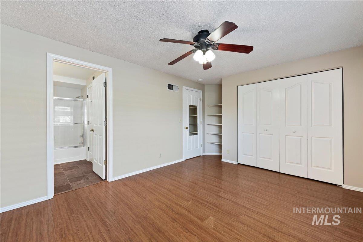 3611 South Gekeler Lane, Unit 124 Boise, ID 83706 - Photo 12 of 27 Unfurnished bedroom featuring a textured ceiling, a closet, dark wood-type flooring, and ceiling fan