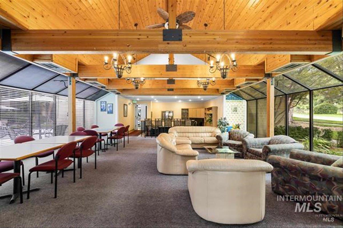 3611 South Gekeler Lane, Unit 124 Boise, ID 83706 - Photo 26 of 27 Carpeted living room with a sunroom, ceiling fan, and a wood ceiling with exposed beams