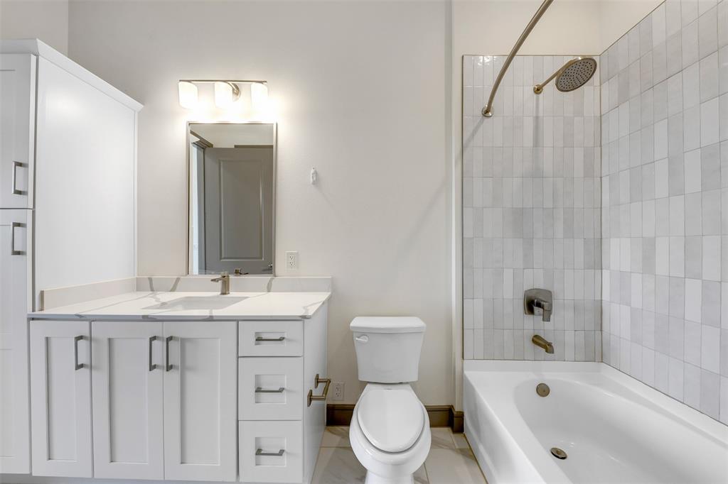 2700 Old Denton Road, Unit 2236 Carrollton, TX 75007 - Photo 17 of 23 a bathroom with a granite countertop toilet a sink and a bathtub