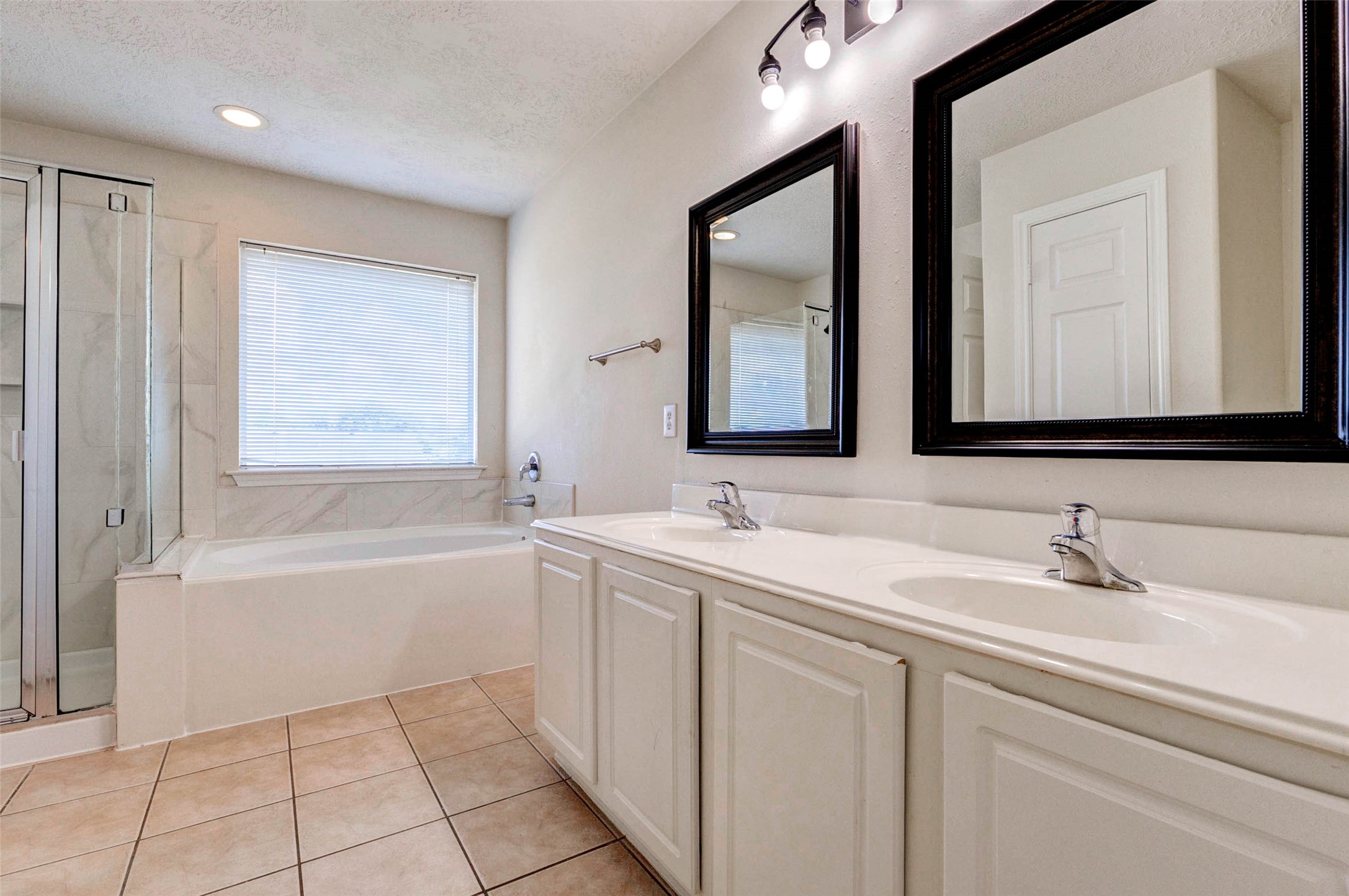 13106 Peppergate Lane Houston, TX 77044 - Photo 13 of 17 a bathroom with a bathtub a sink and a mirror