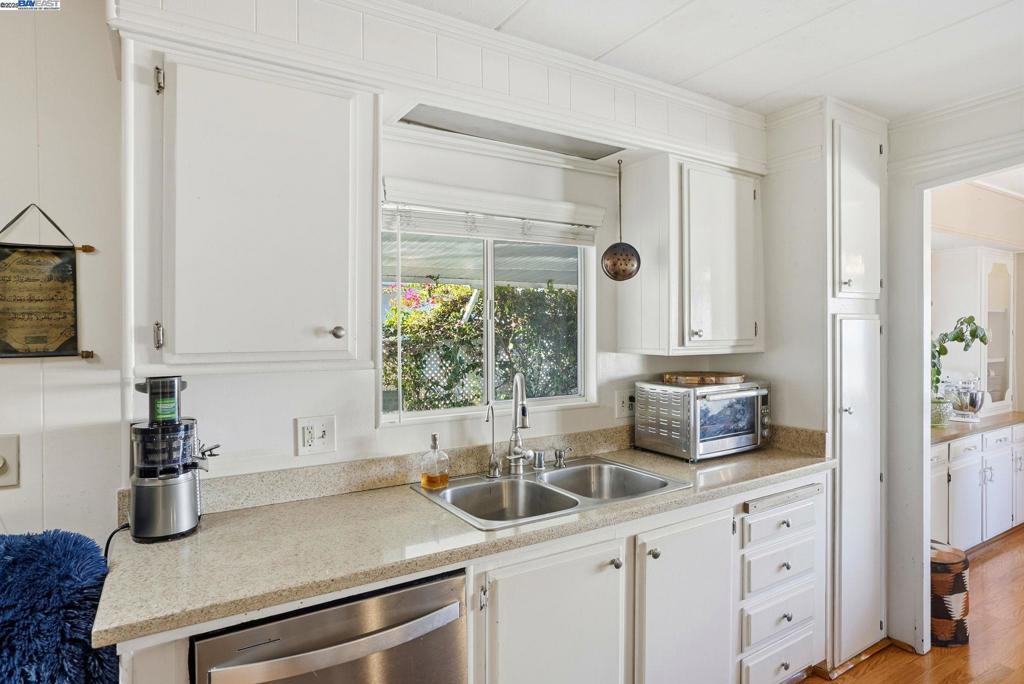 4141 Deep Creek Road Fremont, CA 94555 - Photo 18 of 54 a kitchen with stainless steel appliances a sink a window and white cabinets