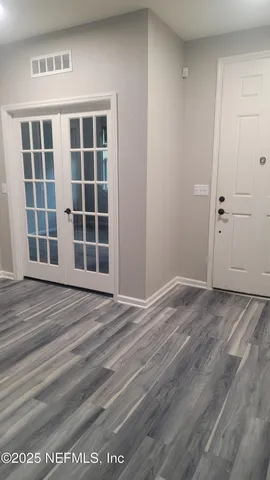 a view of a kitchen with kitchen island wooden floor center island and stainless steel appliances