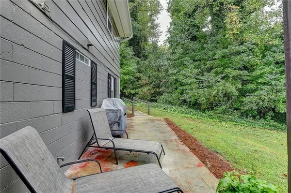 a view of a patio with a table chairs and a backyard