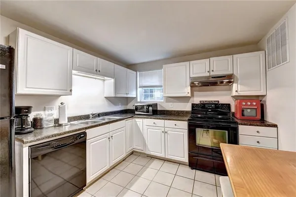 a kitchen with granite countertop a stove sink and cabinets