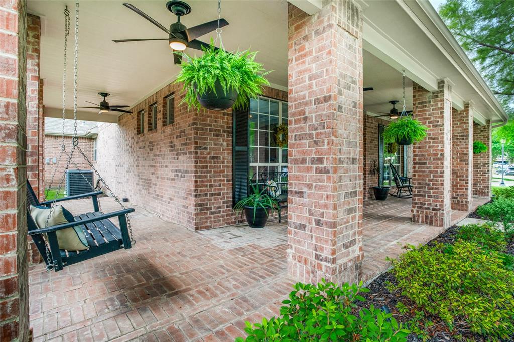 1612 Coventry Lane Allen, TX 75002 - Photo 36 of 39 Brick-paved covered front porch featuring brick columns, multiple ceiling fans, and a porch swing