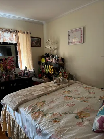 a bedroom with a bed mirror and on the dresser