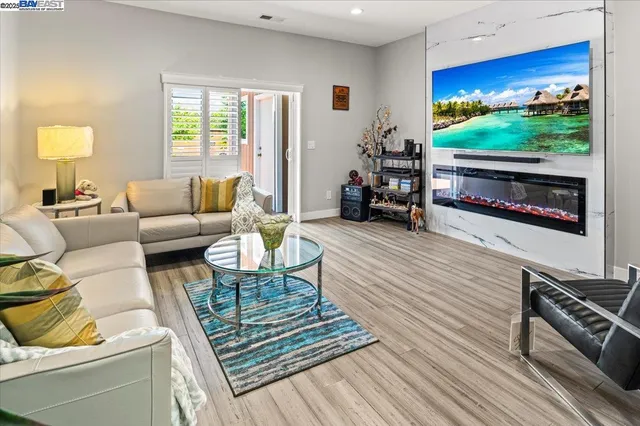 a living room with furniture a flat screen tv and a fireplace