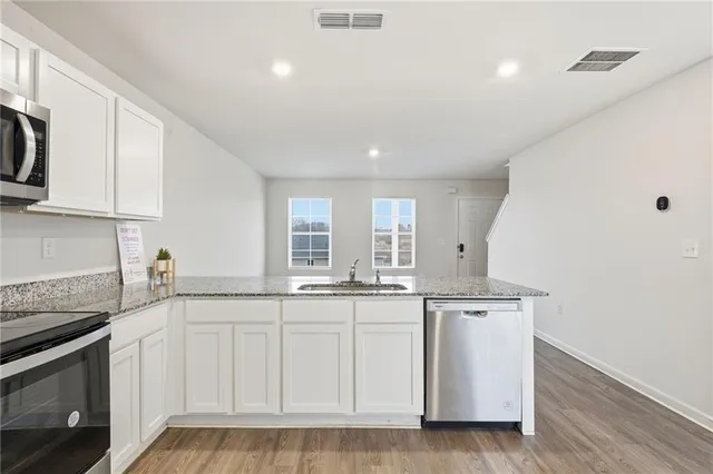a kitchen with white cabinets and sink