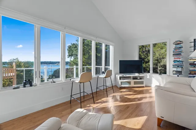a living room with furniture a flat screen tv and a large window