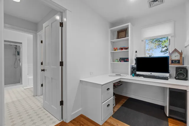a view of a workspace with furniture and a flat screen tv