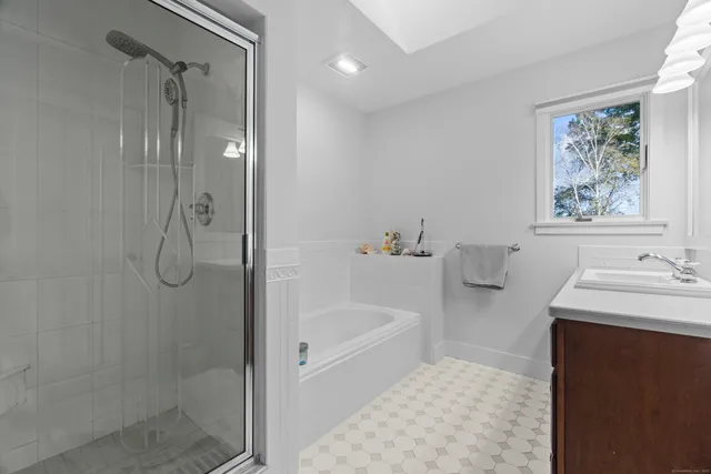 a bathroom with a bath tub a sink and a shower